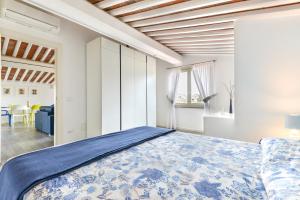 a bedroom with a large bed with a blue bedspread at Tosca in Capoliveri