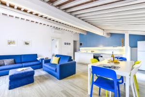 a living room with blue furniture and a white table at Tosca in Capoliveri