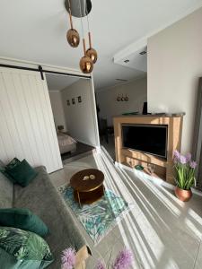 ein Wohnzimmer mit Sofa und Tisch in der Unterkunft Nord House Apartament in Jastrzębia Góra