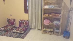 una habitación con 2 sillas y jaulas con ropa en فيلا حبيبه, en ‘Izbat Ţanāţī