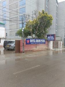 un cartello per aroth grand park di fronte a un edificio di Hotel Grand Pearl a Lahore