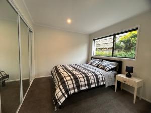 un dormitorio con una cama y una ventana en 2 Beddie by the Bay, en Auckland 18 fotos más