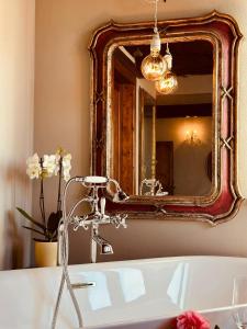 a bathroom with a mirror and a bath tub at Locanda Antico Casale Cesenatico in Cesenatico