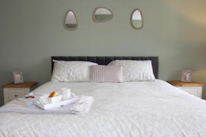 a bedroom with a bed with two mirrors on the wall at Seashell Cottage in Llanddulas