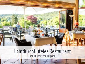 a restaurant with tables and chairs on a patio at Hotel Am Kurhaus mit erstem Ayurveda Center Sachsens - direkt am Gesundheitsbad ACTINON & Kurpark in Bad Schlema