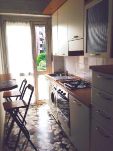 a kitchen with a stove and a sink and a table at Il Cedro Argentato in Monza