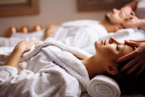 伊拉克利翁鎮的住宿－Ethereal White Resort Hotel & Spa，男人和女人躺在床上毛巾下