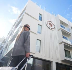 Ethereal White Resort Hotel & Spa في مدينة هيراكيلون: رجل يقف على سور أمام مبنى