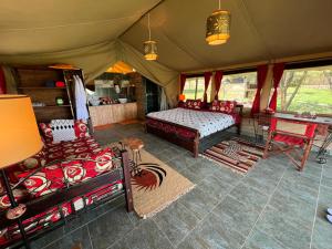 a room with a bed and chairs in a tent at Nyumba ya Farasi in Naivasha
