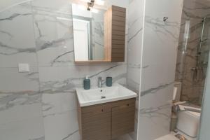 a white bathroom with a sink and a mirror at Hidden Paradise Apartment in Kos Town +17 photos