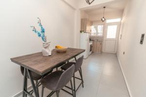 uma cozinha com uma mesa de madeira com cadeiras e um frigorífico em Hidden Paradise Apartment em Cidade de Kos