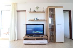 una sala de estar con TV de pantalla plana en un armario en Frische Brise, en Cuxhaven