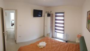 a bedroom with a bed and a television and a window at BigNest in Smederevo