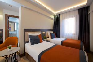 a hotel room with two beds and a table at Hotel Eyfel in Istanbul +74 photos
