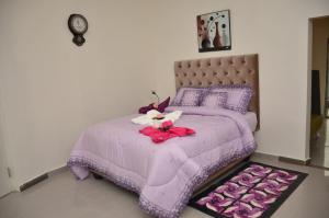 a purple bed with a stuffed animal on it at SPA LAVENDER AND SUITES in Port Harcourt