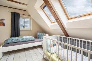 Habitación para bebés con cuna y ventanas en Ferienwohnung Baumann, en Schwarzenberg/Erzgebirge