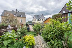 a garden with flowers and plants in a village at Ferienwohnung Baumann in Schwarzenberg/Erzgebirge