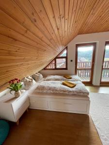 Cama grande en habitación con techo de madera en U farmy, en Velhartice