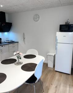 比倫德的住宿－The Heart of Billund apartment，厨房配有白色的桌子和冰箱。