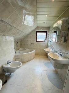 a large bathroom with two sinks and a tub and a tubermott at U farmy in Velhartice