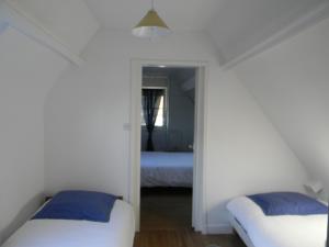 a bedroom with two beds and a mirror at À l'Approche de la Mer in Houlgate