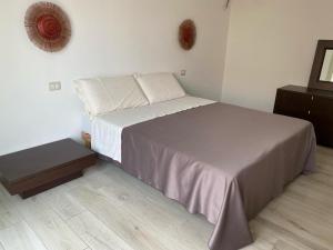 a bedroom with a bed and a wooden floor at Ajo' da Paolo in Budoni