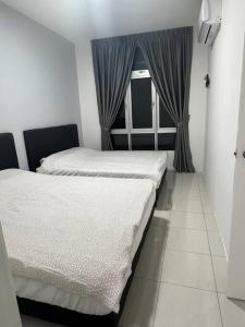 two beds in a room with a window at Ipoh Town Anderson Haru Suite 7 paxs 2R2B in Ipoh
