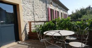 a patio with a table and chairs on a balcony at Au pied du Figuier in Pauligne