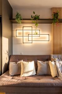 a brown couch with pillows and plants on it at Oasis Urbano Faria Lima in São Paulo