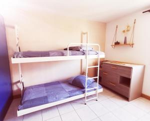 two bunk beds in a room with a desk at Petite maison cosy 4 couchages à 700 m de la plage in Torreilles