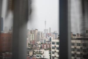 Elle offre une vue sur les toits de la ville depuis sa fenêtre. dans l'établissement Roomme私享家东山口地铁站公寓, à Canton