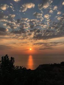 a sunset over the ocean with the sun in the sky at Sette Isole Countryside Studio 1 in Athanion