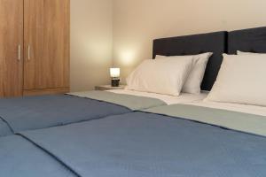 a bedroom with two beds with blue and white at Acapulco Marinos Apartments- Adults Only in Laganas