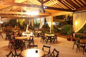 two people sitting at tables in an outdoor restaurant at Casa do Vale Encantado in Furnas