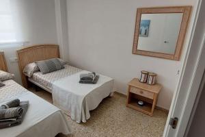 a room with two beds and a mirror on the wall at Apartamento Playa Piles -Familias- in Piles +61 photos