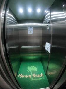 un túnel de cristal con baño con suelo verde en Maraca Beach I - Flat 102 en Porto De Galinhas