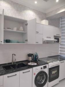 a white kitchen with a washing machine in it at Apart Khujand in Khujand