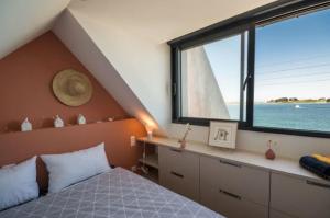 ein Schlafzimmer mit einem Bett und einem großen Fenster in der Unterkunft Ty Wrach in Landéda