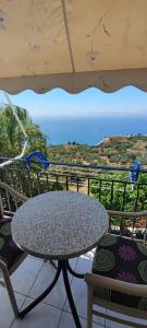 a table and chairs on a balcony with a view of the ocean at Sette Isole Countryside Studio 1 in Athanion