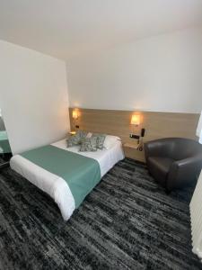 une chambre d'hôtel avec un lit et une chaise dans l'établissement Hotel du Louvre, à Cherbourg en Cotentin