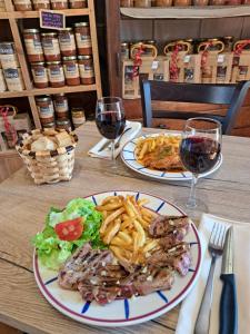 a table with two plates of food and two glasses of wine at Ferme Auberge Ibarnia in Lecumberry
