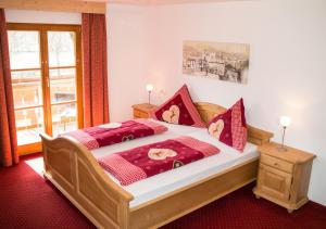 a bedroom with a large bed with red pillows at Pension Carina in Füssen