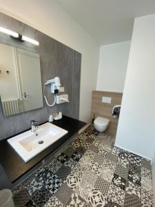 un baño con lavabo e inodoro en Hotel du Louvre, en Cherbourg-en-Cotentin