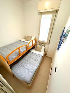 2 łóżka w małym pokoju z oknem w obiekcie Giardino al mare w Rimini