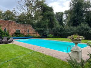 a swimming pool in a yard next to a house at The Cottage in Yoxall