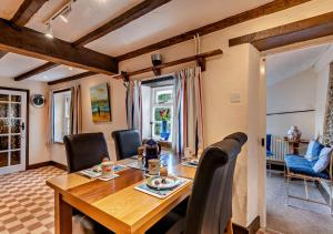 a dining room with a wooden table and chairs at Pitts Cottage in Brancaster