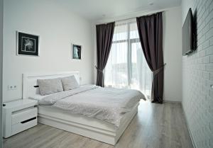 um quarto branco com uma cama e uma janela em Апартаменты в Аркадии - Arcadia Sky Apartments em Odessa