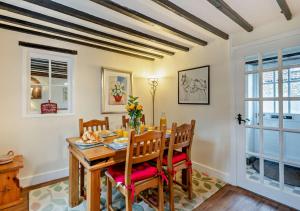 a dining room with a wooden table and chairs at Barmstone Cottage in Brancaster