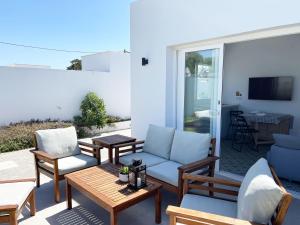 un patio con sillas, un sofá y una mesa en Agoodplan Aitana Playa El Palmar, en El Palmar