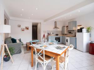 eine Küche und ein Wohnzimmer mit einem Tisch und Stühlen in der Unterkunft Le cocon d'Emile - Cosy et tout équipé in Nancy